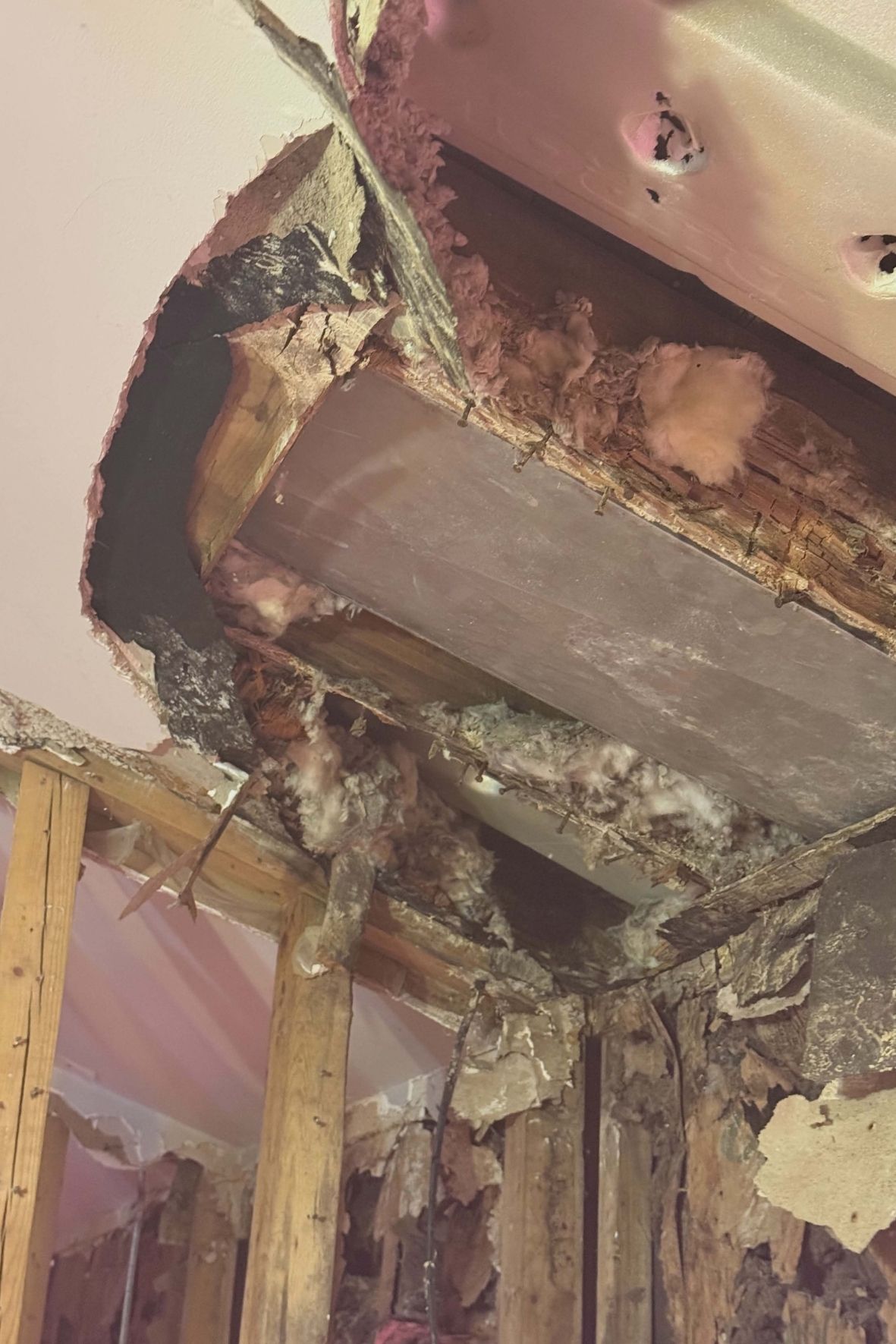 Charpente murale et plafond partiellement ouverts avec isolant apparent dans une maison  à Brossard